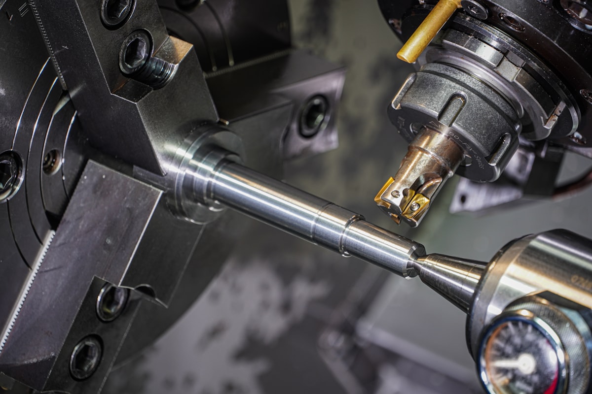 A shaft turned to size in a lathe chuck under a cutting tool